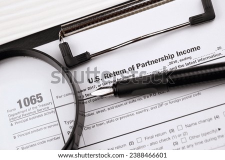 IRS Form 1065 US Return of Partnership Income blank on A4 tablet lies on office table with pen and magnifying glass close up Royalty-Free Stock Photo #2388466601