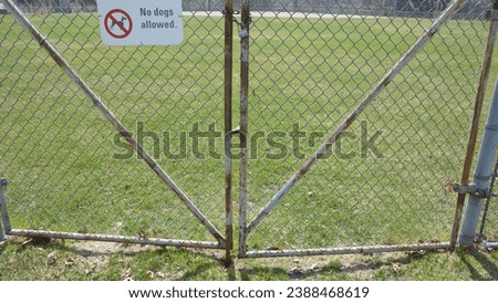 sign with no dogs allowed on the playing field in the park