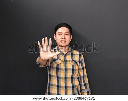 A portrait of Asian young man make a gesture to stop