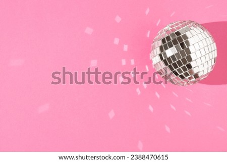 Disco ball on a pastel pink background. The concept of minimal entertainment. Flat lay. Royalty-Free Stock Photo #2388470615