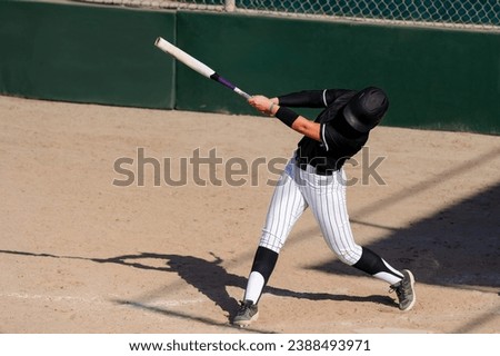 A Baseball Softball Player Is Swinging The Bat Hitting The Ball