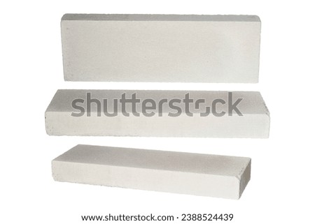 Aerated Concrete block isolated on white background. White lightweight brick, house wall assembly made from white aerated autoclaved concrete block. Solid gypsum modular pattern for light building. Royalty-Free Stock Photo #2388524439