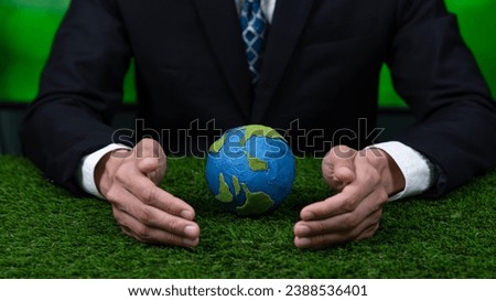 Businessman holding planet Earth globe symbolize eco-friendly business commitment to environmental protection and zero carbon emission. Earth World Day concept to promote eco awareness. Gyre