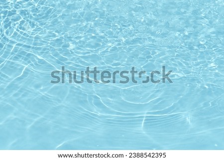Defocus blurred transparent blue water drops on surface texture with splashes reflection. Trendy abstract nature background. Water waves in sunlight with copy space. Blue watercolor shine.