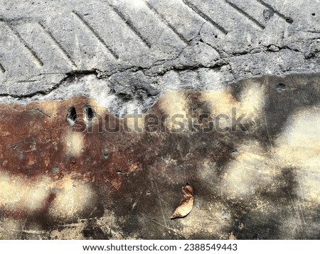 a rusty metal plate on a concrete surface.