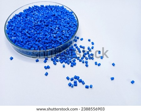Blue color polymer masterbatch granules in petri dish isolated on white background suitable for plastic company profile product photo catalog background design