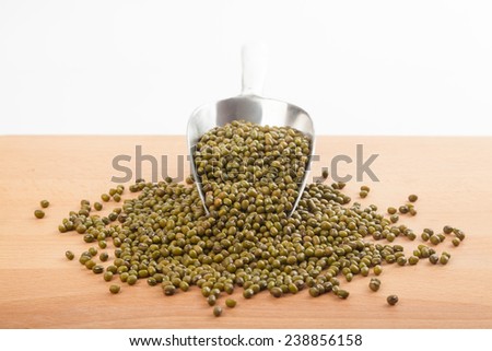 Mung beans with transfer scoop on wood table