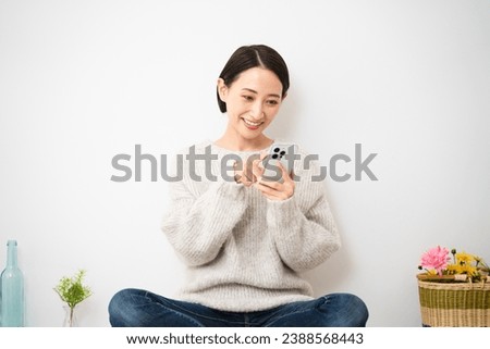 Lifestyle image of a young woman operating a smartphone