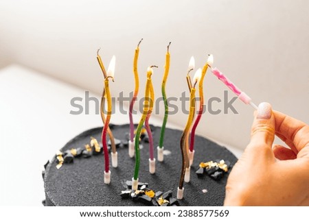 Black and yellow birthday cake with candles