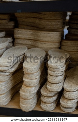 Slippers and shoes soles top view in handicraft store, craft supplies lying on a shelf t in handmade shop vertical photo