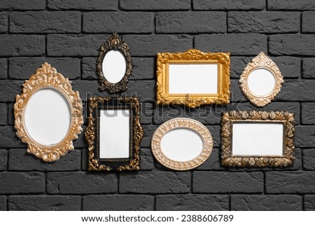 Empty vintage frames hanging on dark brick wall. Mockup for design
