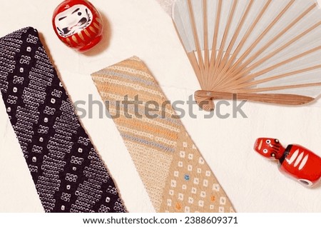 Image of Japanese souvenirs for foreign tourists. Akabeko(shape of a red cow), Daruma(red and round one), Japanese tie dye ties and Japanese hand fan.