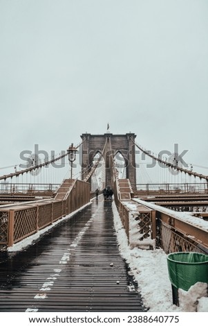 Photo of Brooklyn Bridge with snow in a cloudy day, Manhattan, New York City.