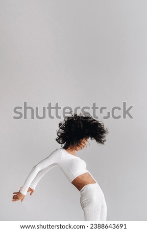 A woman in white sportswear is engaged in dynamic kali meditation in the yoga hall.