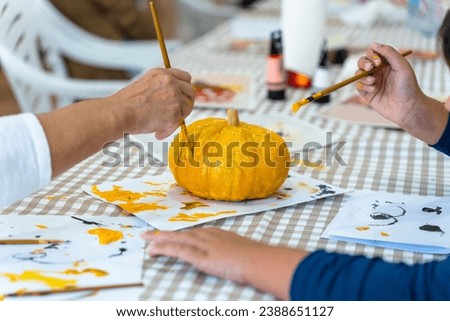 Children's painting class. Painting day with parents in class painting pumpkins.
