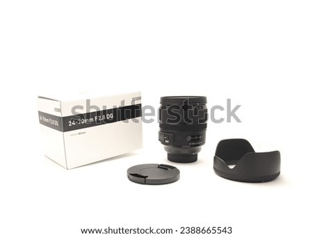 Box, cap, hood and brand-new advanced aspherical landscape lens with cap made in Japan for DSLR full frame camera photography isolated on white background, clipping path copy space. Digital photo