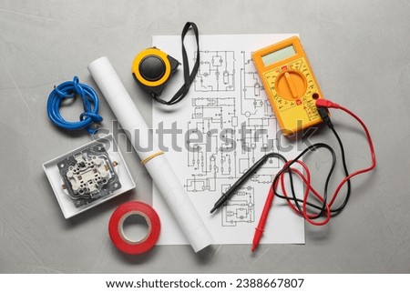 Wiring diagram, wires and digital multimeter on light grey table, flat lay Royalty-Free Stock Photo #2388667807