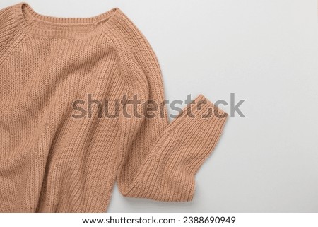 Green knitted sweater on paper green background top view copy space. Texture of woolen cotton winter autumn cozy sweater, clothes. Knitted jumper, pullover, fashion. Sweater close-up Royalty-Free Stock Photo #2388690949