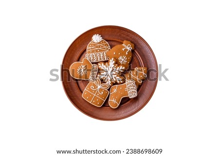 Beautiful Christmas gingerbread cookies of different colors on a ceramic plate on a dark concrete table