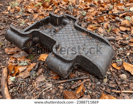 Among the fallen brown leaves lies a piece of metal track - a relic of an armored self-propelled vehicle from World War II. This juxtaposition evokes a poignant reminder of history Royalty-Free Stock Photo #2388711869