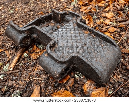 Among the fallen brown leaves lies a piece of metal track - a relic of an armored self-propelled vehicle from World War II. This juxtaposition evokes a poignant reminder of history Royalty-Free Stock Photo #2388711873