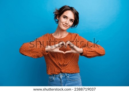 Photo of cheerful pretty lady showing heart symbol with her arms showing love to boyfriend isolated blue color background