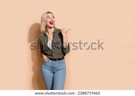 Portrait of shocked funny lady showing sale offer banner good news wearing smart casual clothes isolated beige color background