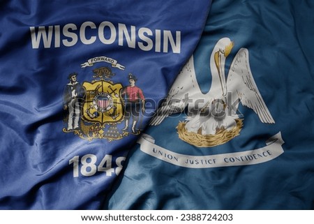 big waving colorful national flag of louisiana state and flag of wisconsin state . macro