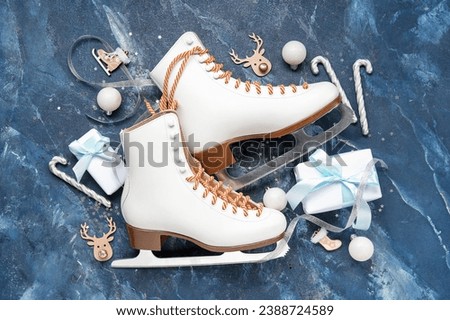 Composition with ice skates, Christmas decorations and gifts on color background