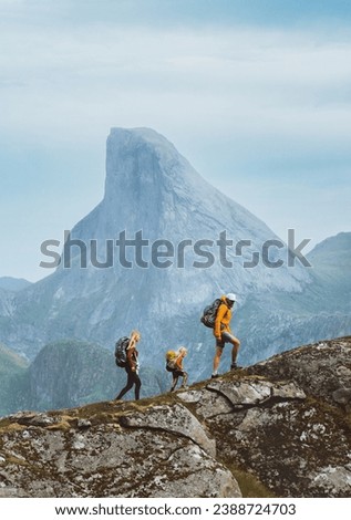Family hiking in Norway mountains, active vacations with backpack outdoor. Parents and child traveling together healthy lifestyle adventure tour with mother, father and kid trekking in Lofoten islands Royalty-Free Stock Photo #2388724703