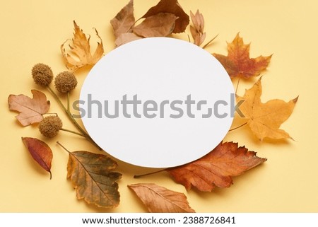Round blank card with autumn leaves on yellow background