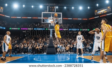 African American National Basketball Superstar Player Scoring a Powerful Slam Dunk Goal with Both Hands In Front Of Cheering Audience Of Fans. Cinematic Sports Shot with Back View Action.