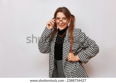 A female student in glasses, a checkered jacket and a backpack.