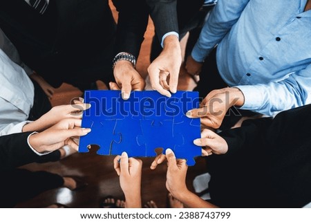 Top view multiethnic business people holding jigsaw pieces and merge them together as effective solution solving teamwork, shared vision and common goal combining diverse talent. Meticulous Royalty-Free Stock Photo #2388743799