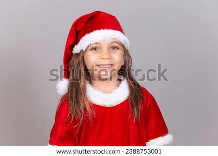 Adorable Caucasian child dressed in Christmas outfit smiling at camera with free space for text