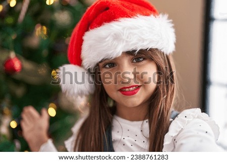 Adorable hispanic girl smiling confident make selfie standing by christmas tree at home