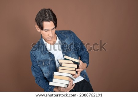 Young man and study. Funny attractive guy posing on a brown background.