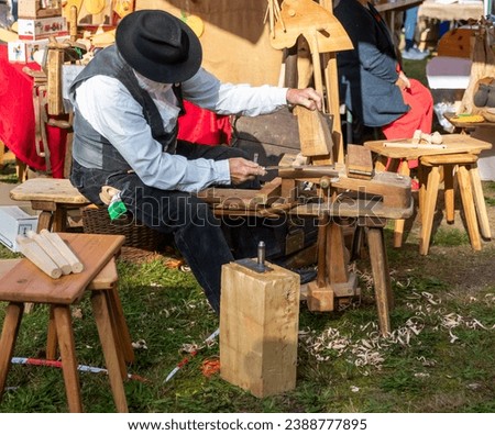 craftsman makes wooden objects on an market