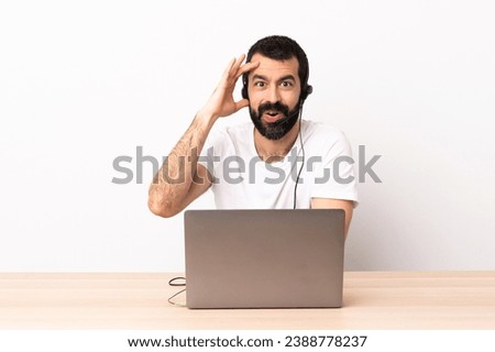 Telemarketer caucasian man working with a headset and with laptop has realized something and intending the solution.