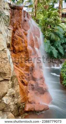 Indoor artificial waterfall with slow shutter speed for blurred view.