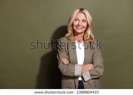Portrait of beautiful mature confident lady folded arms looking empty space planning professional career isolated on khaki color background
