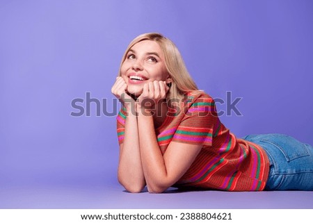 Portrait photo of young pretty smiling woman hands touch cheekbones looking above head admiring isolated on violet color background