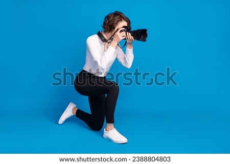 Full size profile portrait of paparazzi stand on knee making photos isolated on blue color background
