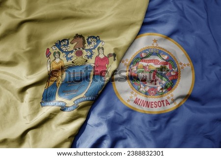 big waving colorful national flag of minnesota state and flag of new jersey state . macro