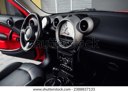 Compact, stylish and youthful crossover in bright red color. Modern black car interior.  Details interior.  Royalty-Free Stock Photo #2388837133