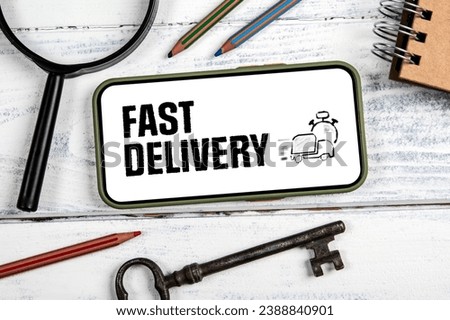 Fast Delivery Concept. Mobile phone on a white wooden background.