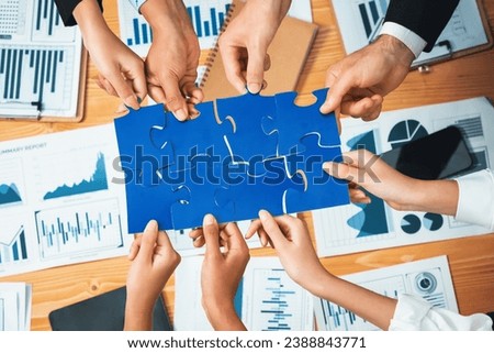 Multiethnic business people holding jigsaw pieces and merge them together as effective solution solving teamwork, shared vision and common goal combining diverse talent. Habiliment Royalty-Free Stock Photo #2388843771