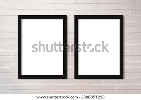 Full frame close up on a brick wall painted in white with two vertical picture frames with copy space.