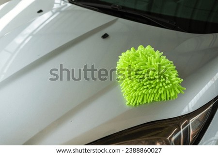 A Microfiber Wash Mitt on the Car Hood. Car Detailing and Cleaning Concept with Space for Copy