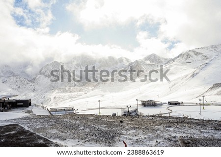 Snowy landscape with snowy mountains in the background, with a gas station in the middle of the background
